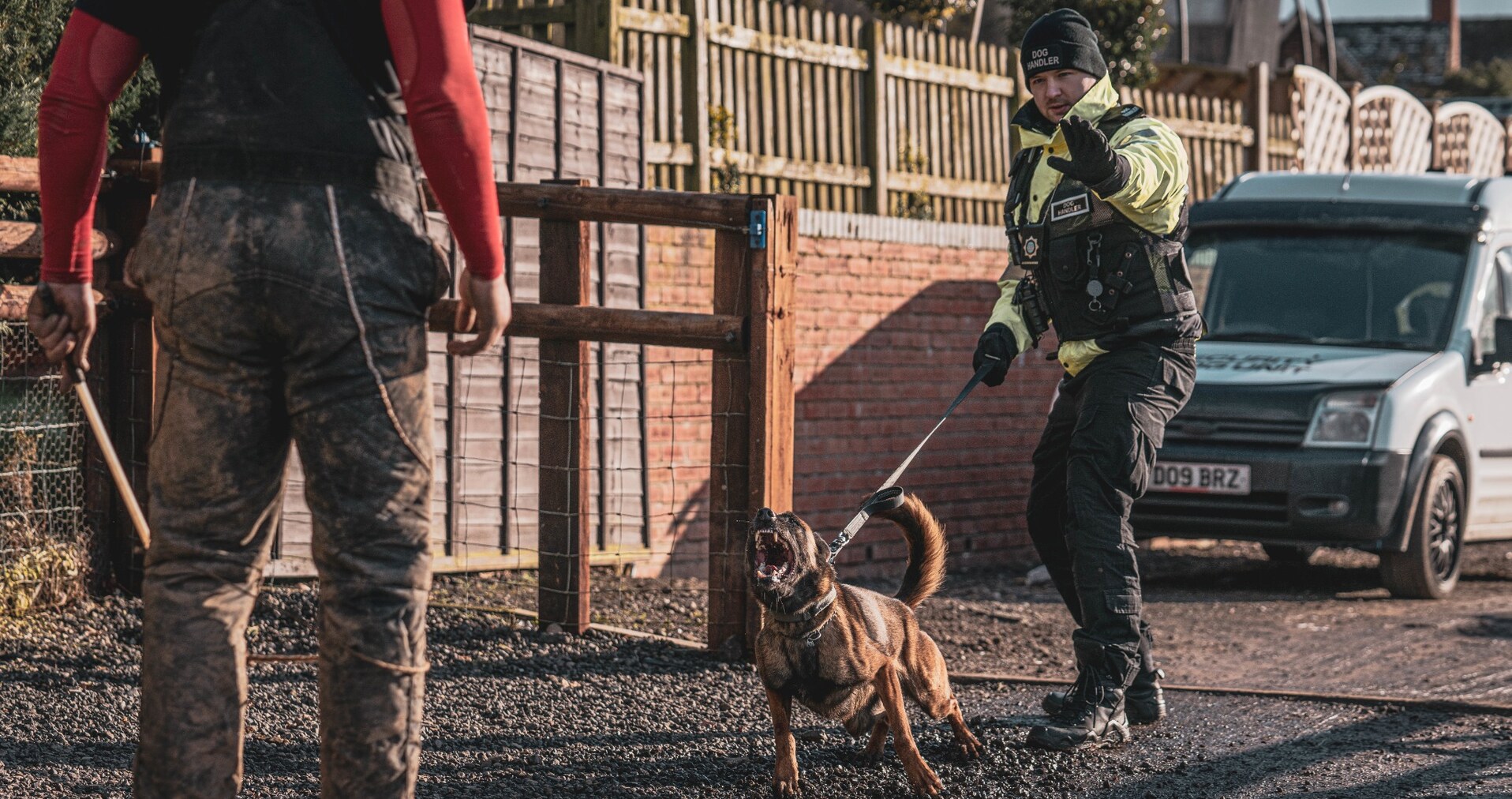 Security dog handler services in action, with a trained security dog and professional handler responding to a potential site threat.