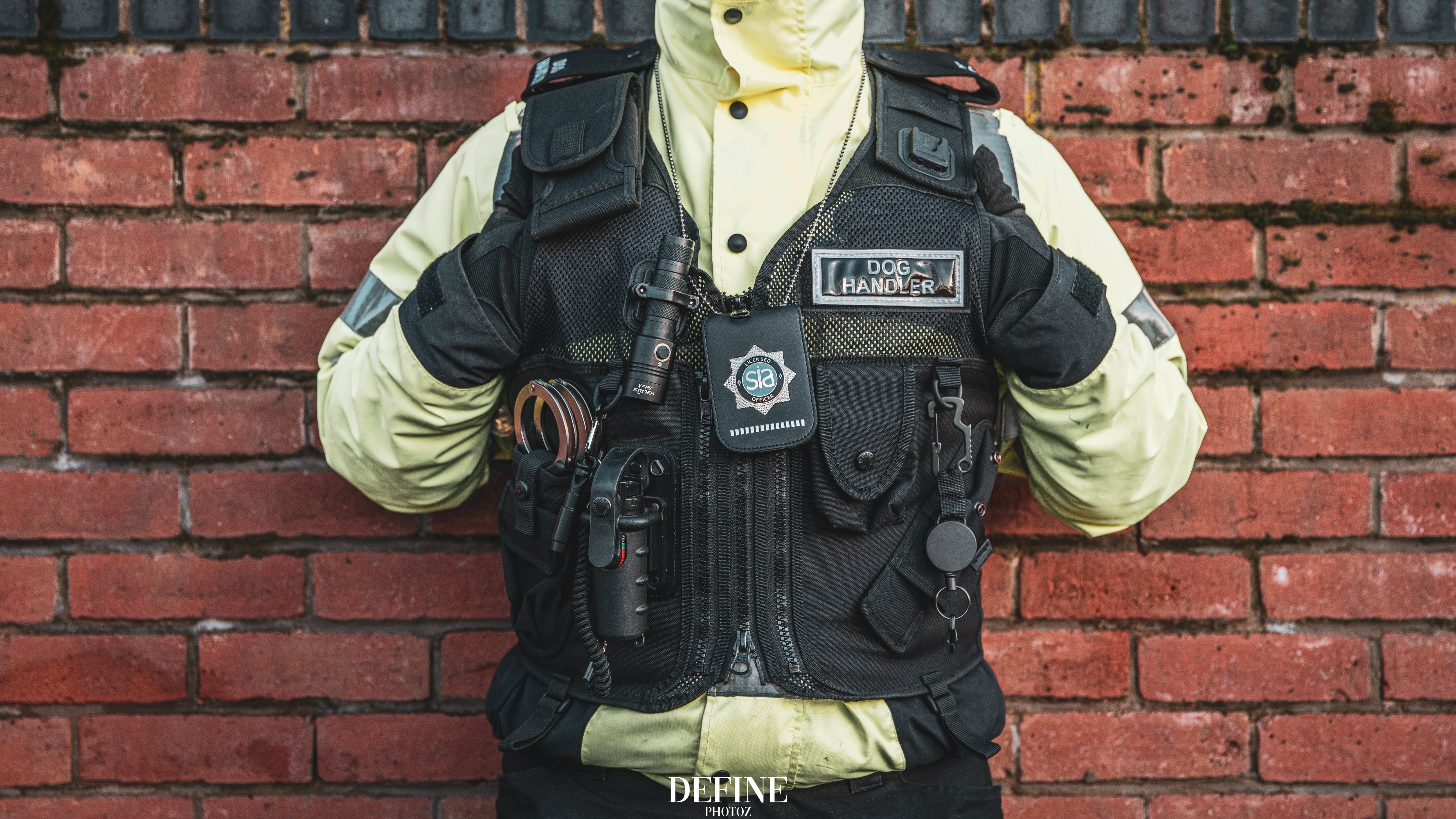 Dog handler wearing a protective vest and high-visibility jacket